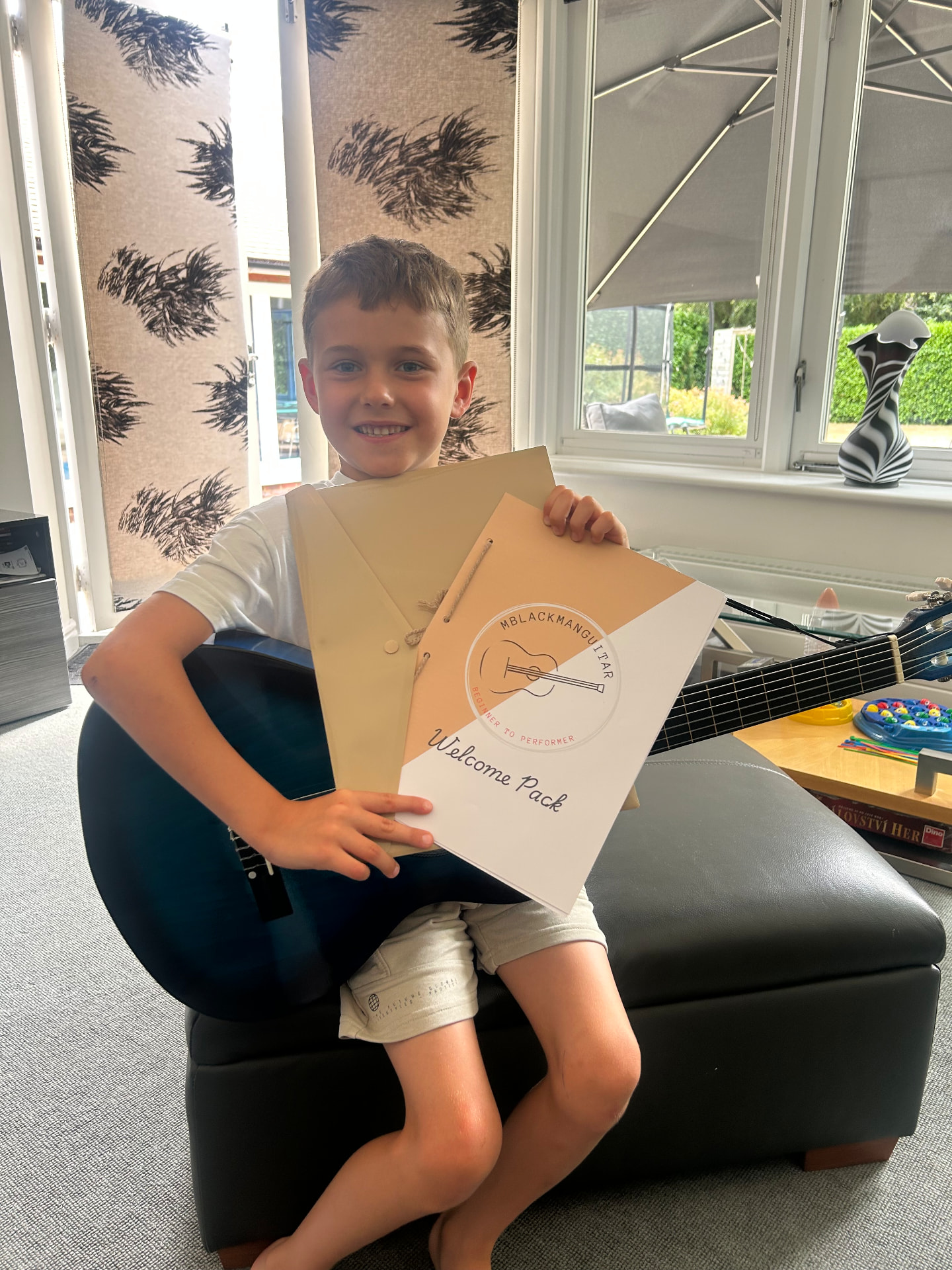 Young student with a guitar and MBlackmanGuitar welcome pack